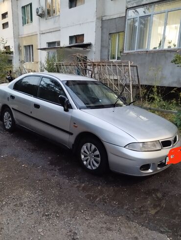 арзан авто машина: Серебристый седан Mitsubishi Carisma с четырьмя дверями и
