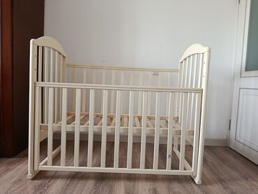 пол деревянный: Детская кроватка из светлого дерева, выполненная в классическом стиле