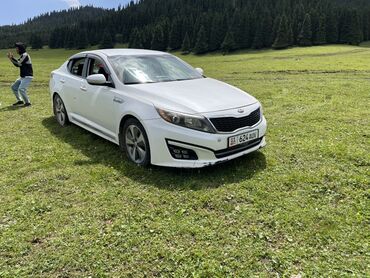 красные машины: Белый седан Kia Optima с динамичным дизайном. Автомобиль оснащен
