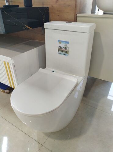 Ağ rəngli, bütöv dizaynlı tualet. Bu model həm estetik görünüşü, həm