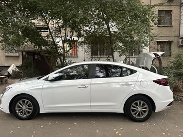 автокредит без первоначального взноса бишкек: Белый седан Hyundai Elantra с открытым багажником, демонстрирующий