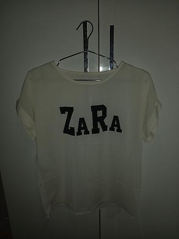 yay krasovkalari: Ağ rəngli qısaqoll bluzka. Ön hissədə iri qara “ZARA” yazısı var — 1