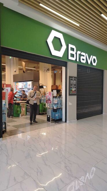 Mağazalar: Bravo supermarketinin girişindəki səhnə. Mağaza adının iri, işıqlı
