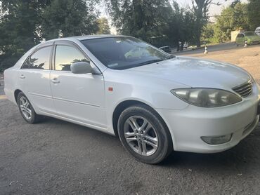портерге шина: Белый седан Toyota Camry с тонированными стеклами и легкосплавными