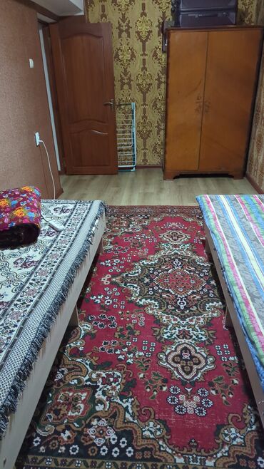 односпальные кравати: Две односпальные кровати с деревянными каркасами. Кровати застелены