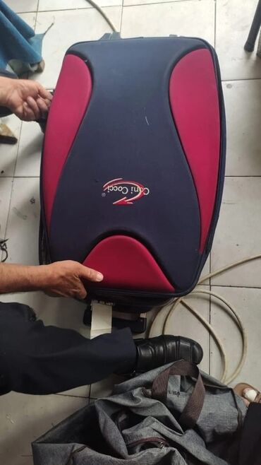 Giryalar: Cani Cocci loqolu tünd göy və qırmızı rənglərdə olan səyahət çamadanı