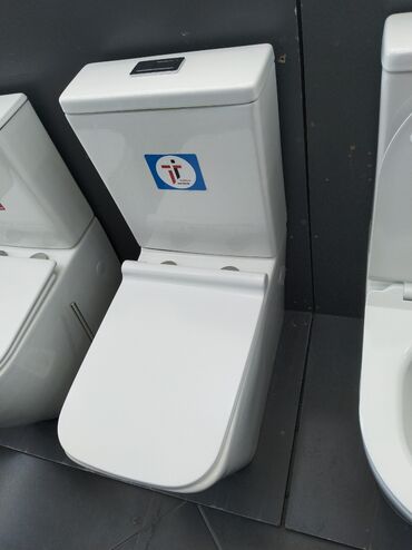 Hamam üçün aksessuarlar: Ağ rəngdə, müasir dizaynlı unitaz. Bu unitaz, həm evdə, həm də ofisdə