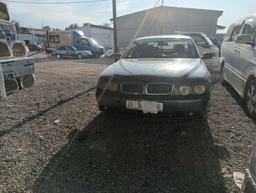 семёрка машина: Седан BMW 7 серии, представленный в темно-сером цвете, оснащен