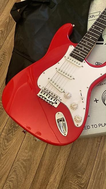 Qırmızı rəngli elektro gitara dəsti. Strat tipli korpusa malik gitara