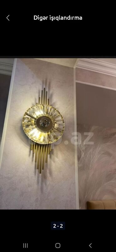 bra: Qızılı rəngli, dekorativ divar lampası. Müasir dizaynı ilə seçilir və