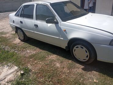 машиналар: Белый седан Daewoo Nexia, оснащенный четырьмя дверями и передним