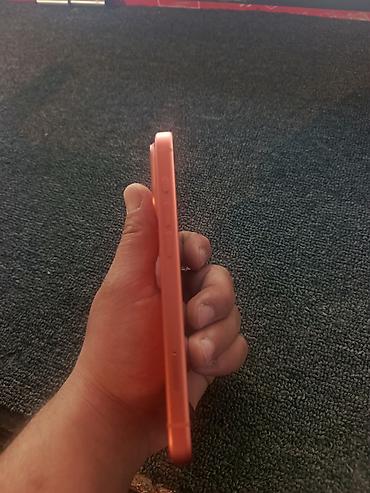 iphone 16e azerbaycan: Narıncı rəngdə smartfon (iPhone dizaynlı), arxa paneldə üçlü kamera — 4
