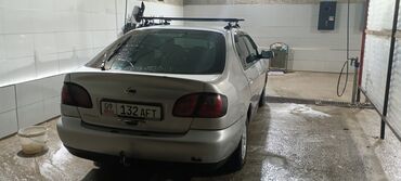 фары на некси: Серебристый седан Nissan Primera с багажником на крыше. Автомобиль