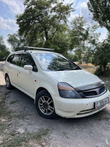 сут машине: Белый минивэн Honda Stream с багажником на крыше. Автомобиль оснащен