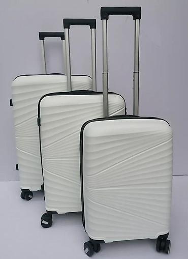 Putni koferi i torbe: === PART 1: TEXTUAL DESCRIPTION === Set od tri bela kofera sa tvrdim — 2