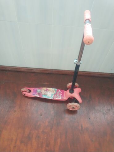 Çəhrayı rəngli uşaq skuteridir. Skuterin üç təkəri var: öndə iki