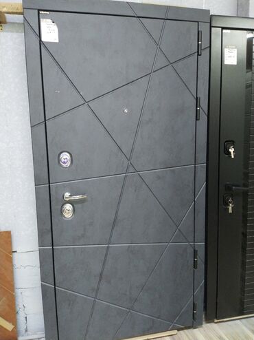 Təmir və tikinti: Qapının boz rəngdə metal konstruksiyası var və üzərində müasir həndəsi
