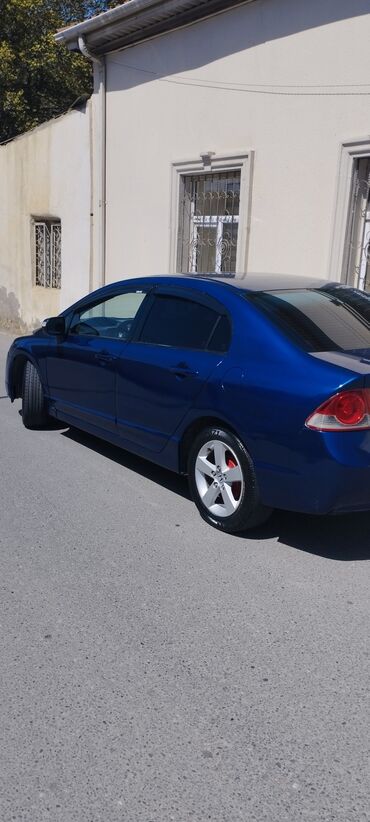 Honda: Mavi rəngdə olan Honda Civic sedanı. Şəhər yollarında rahat hərəkət