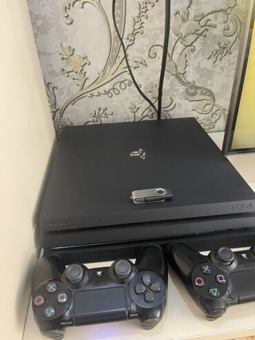 заказать плейстейшен 4: Sony PlayStation 4 Pro konsolu qara rəngdədir və iki ədəd qara rəngli