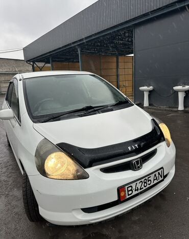 купить кожаные сиденья для авто бу: Белый хэтчбек Honda Fit. Оснащен черным дефлектором капота. Автомобиль