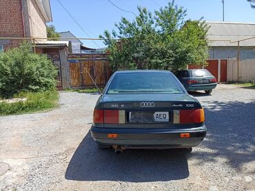 вета машина: Седан Audi 100 темно-зеленого цвета. Эта модель известна своей