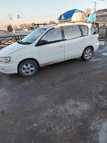 Просторный 5‑дверный минивэн белого цвета. Основные особенности: -