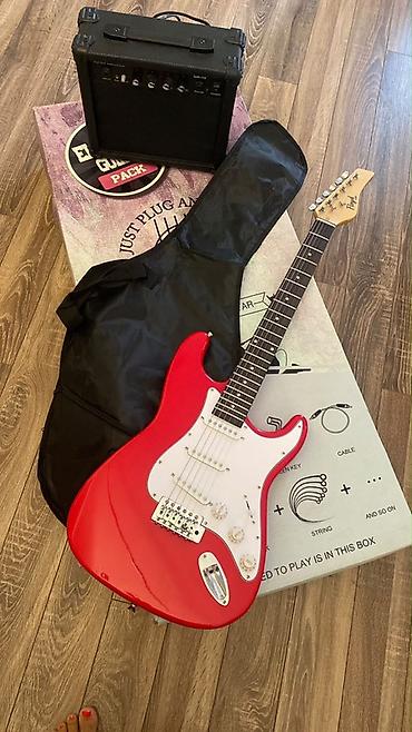 gitara tarnada: Qırmızı rəngli elektro gitara dəsti. Strat tipli korpusa malik gitara — 2