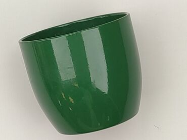 Zielona, ceramiczna osłonka na doniczkę. Ma lekko pochyloną