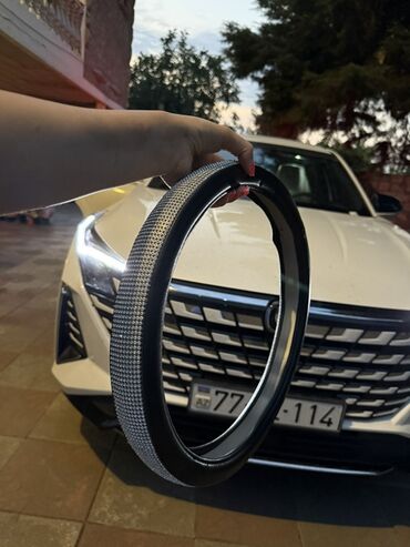авто ремни: Avtomobil sükanının qara rəngdə, parıltılı daşlarla bəzədilmiş örtüyü