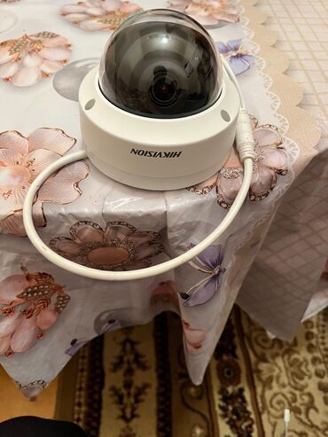 Ağ rəngli, qübbə formalı Hikvision təhlükəsizlik kamerası. Kamera