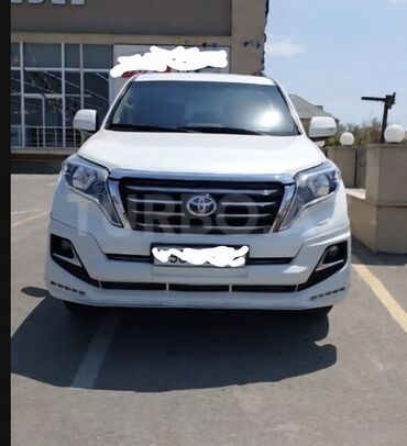 qadın maşını: Ön görünüşü ağ rəngli, iri ön radiator barmaqlığı olan bu Toyota Land