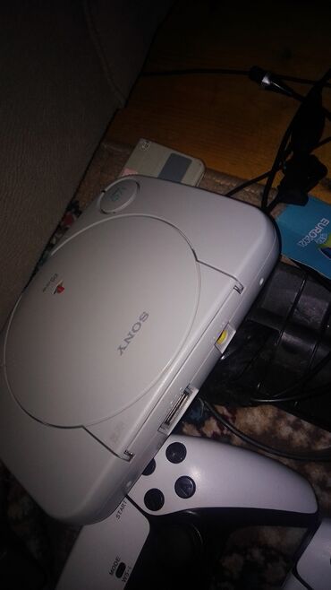 усилители б у: Sony PlayStation One oyun konsolu. Ağ rəngdədir, yığcam dizaynı ilə