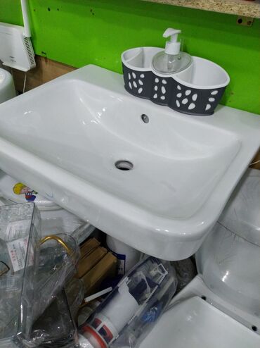 Ağ rəngdə, düzbucaqlı formalı seramik lavabo. Divara montaj üçün