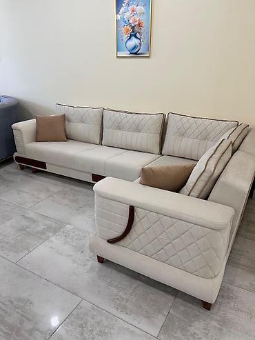Divanlar: Ağ rəngdə, L formalı künc divan. Parça ilə üzlənmiş bu divan, yastıqlı — 1