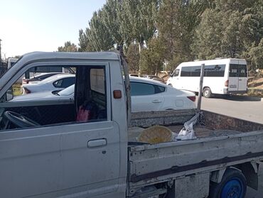 грузовые машины в лизинг: Компактный пикап белого цвета, оснащенный открытым кузовом для