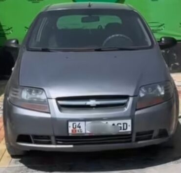 маленькая машина: Серый пятидверный хэтчбек Chevrolet Aveo. Автомобиль оснащен передними