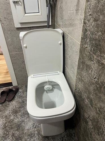 divar içi unitaz: Ağ rəngdə unitaz, standart ölçülərə malikdir və hər bir müasir vanna