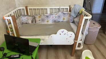 продаю кровати: Белая детская кроватка с деревянными элементами, предназначенная для