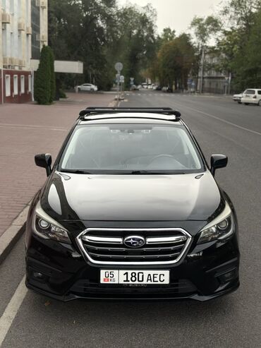спортивные машины: Черный седан Subaru Legacy, оснащенный багажными рейлингами на крыше