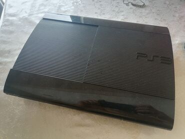 PS3 (Sony PlayStation 3): Qara rəngdə olan Sony PlayStation 3 oyun konsolu. Bu model evdə