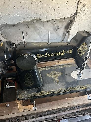 olinpia yazi makinasi: Łucznik markalı qara rəngli mexaniki tikiş maşını. Gövdəsində qızılı — 1
