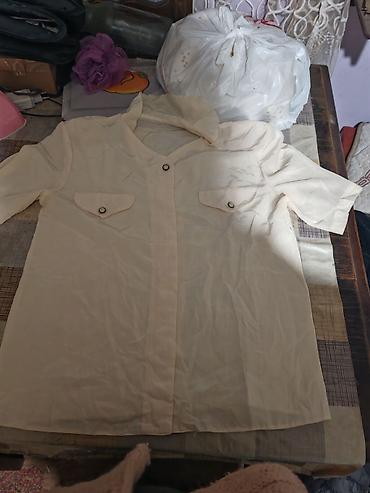 Krem košulja/bluza sa kratkim rukavima i kragnom na preklop. Model