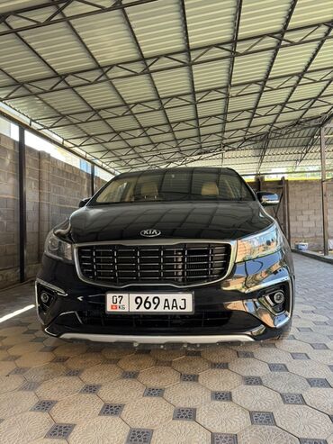 семиместные машины: Черный минивэн Kia Carnival. Модель оснащена хромированной решеткой