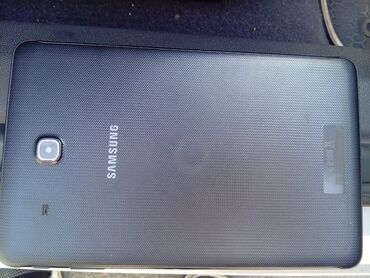 Stəkanlar: Samsung brendinin qara rəngli planşeti. Arxa tərəfində kamera və