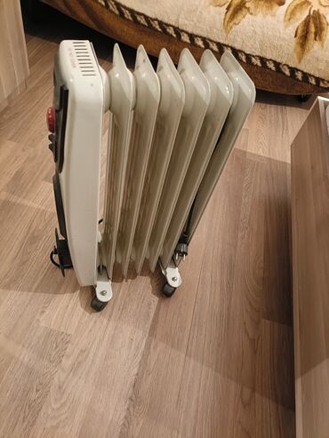 Информатика: Təkərlər üzərində ağ rəngli elektrik yağ qızdırıcısı. Bu model daşınma