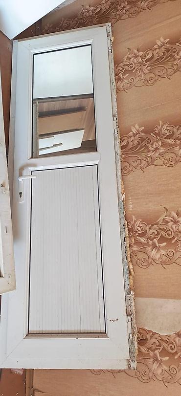 Ağ rəngli PVC qapı satılır. Qapı üzərində yuxarı hissədə şüşəli panel