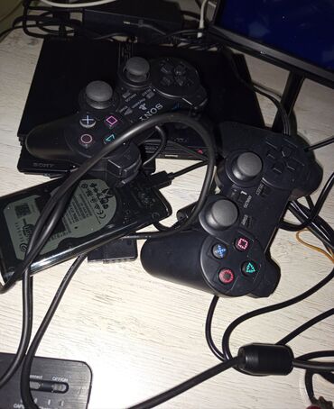 PS2 & PS1 (Sony PlayStation 2 & 1): Sony PlayStation 2 oyun konsolu, iki ədəd qara rəngli idarəetmə pultu