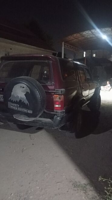 авто для охоты: Полноприводный внедорожник бордового цвета с запасным колесом