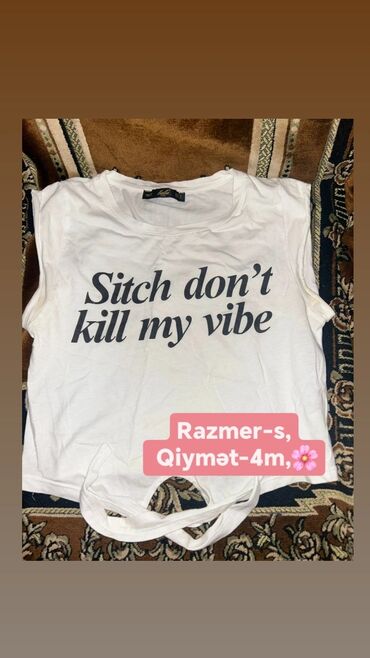 Digər qadın geyimləri: Ağ rəngli, qısaqol köynək, üzərində "Sitch don't kill my vibe" yazısı