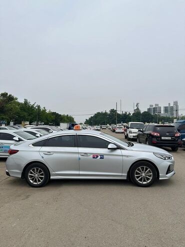 автомобиль легковой: Серебристый седан Hyundai Sonata, оснащенный световым коробом такси на